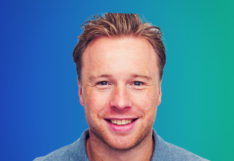 A headshot of a smiling person with light hair, shown against a blue and green gradient background.