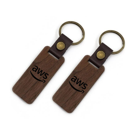 Two rectangular wooden AWS keychains with brown leather strap and brass rings, featuring the AWS logo.
