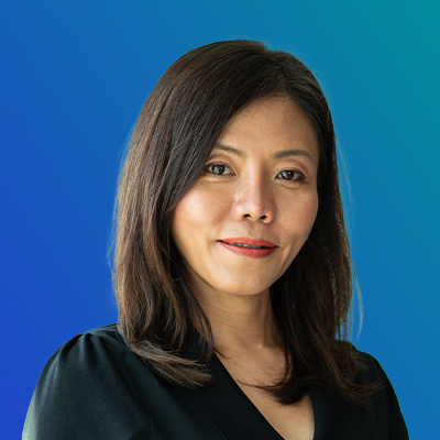 A person with shoulder-length dark brown hair wearing a black top, set against a blue gradient background.