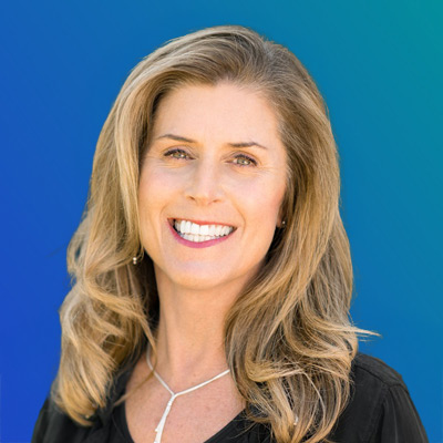 A person with blonde, wavy hair wearing a black top and a silver necklace, set against a blue gradient background.
