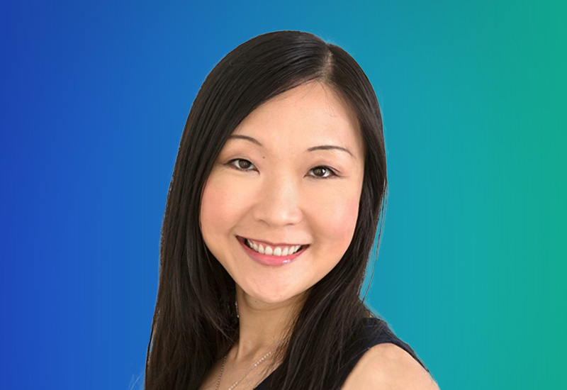 A person with long, straight black hair against a gradient blue and green background.