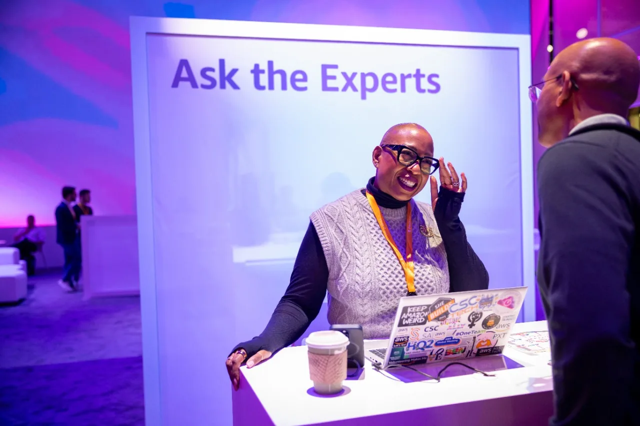 Presenter at an Ask the Experts station talking with an attendee.