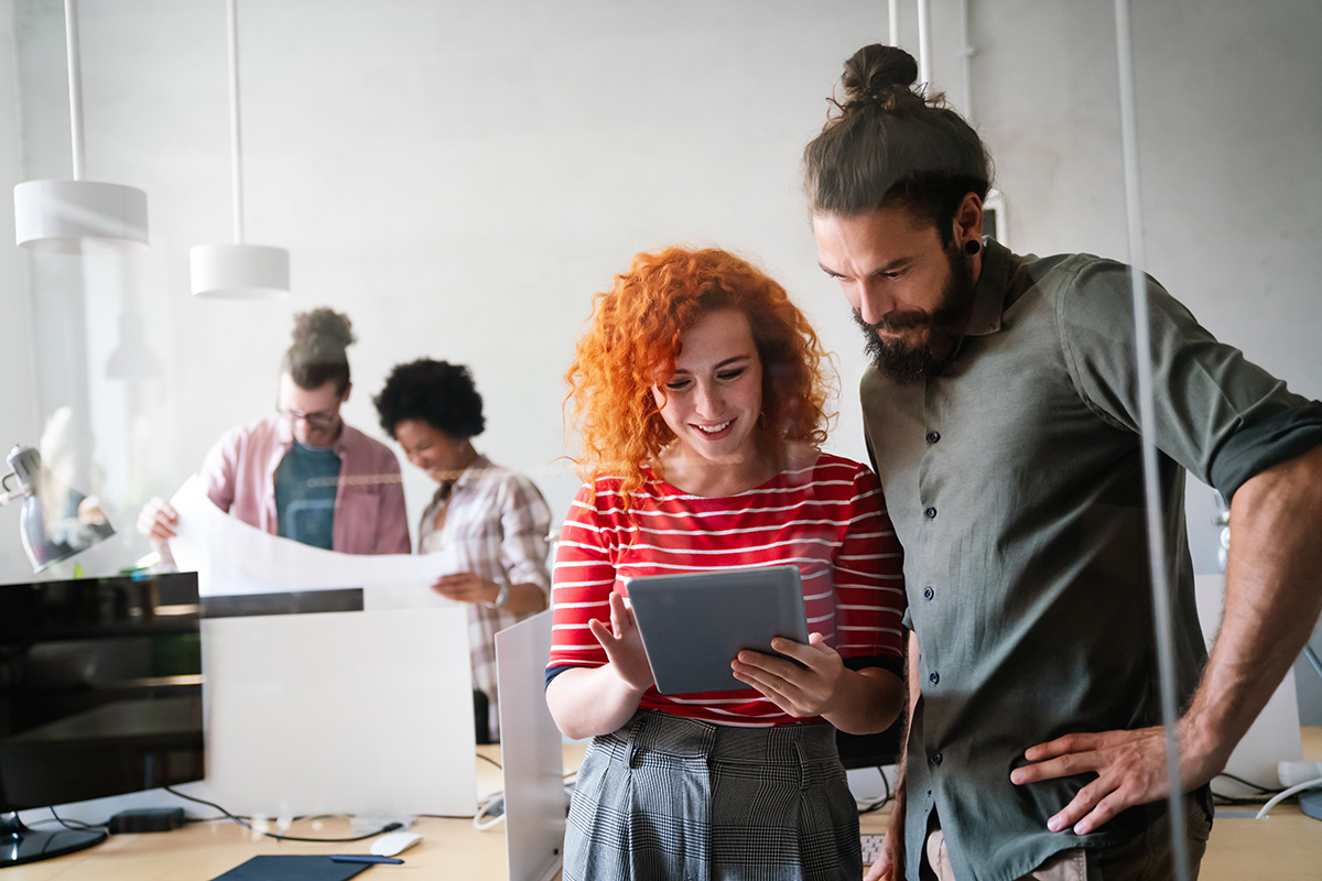 Group of multiethnic business people and software developers working as a team in modern startup office