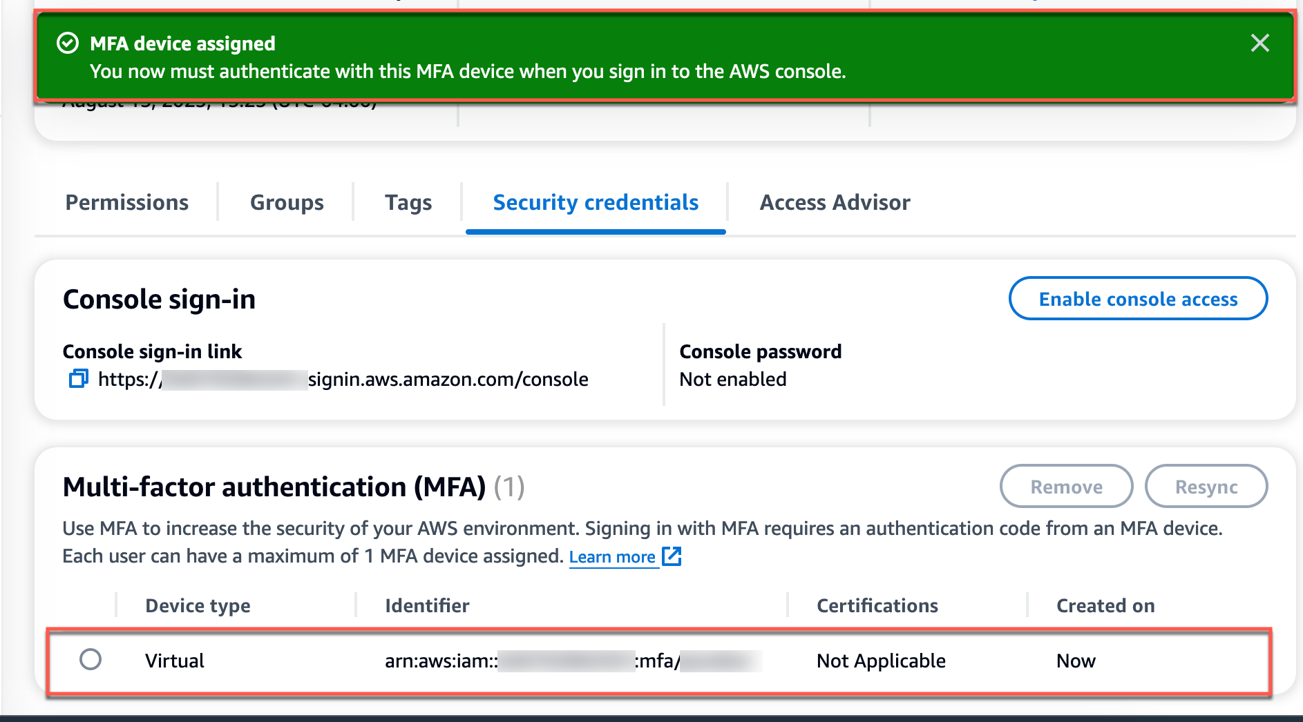 "Screenshot of AWS Security Credentials page showing a green notification banner stating 'MFA device assigned,' with details of a virtual MFA device listed below."