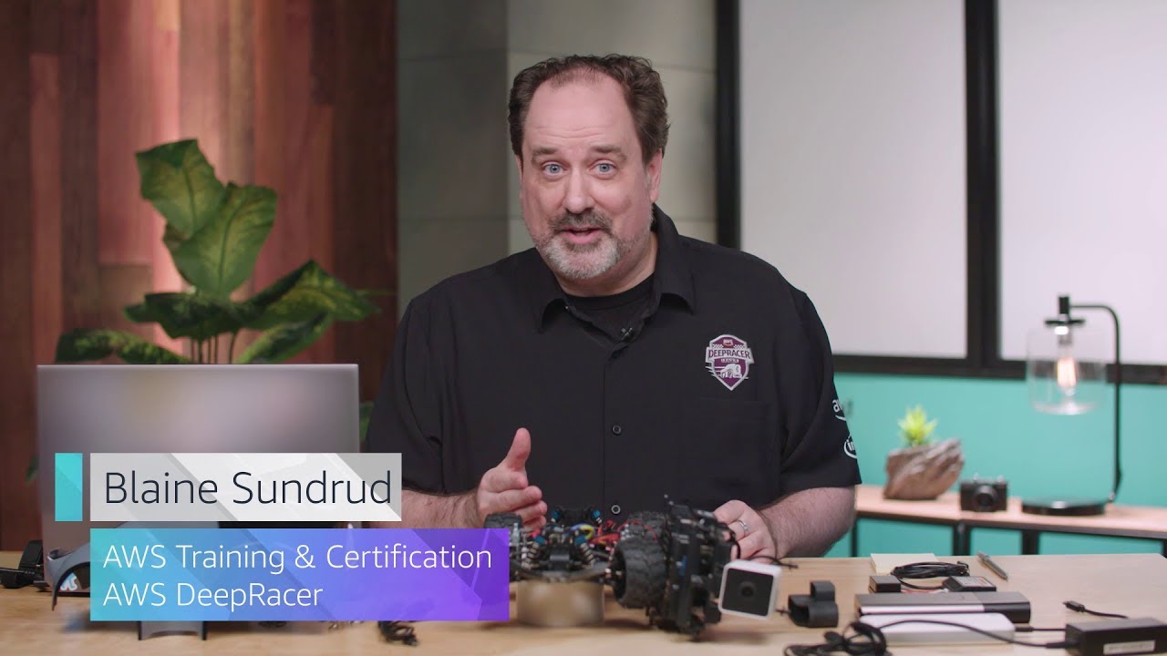 A person presenting in a studio with AWS DeepRacer components on the table, shown in a YouTube thumbnail for AWS Training & Certification.