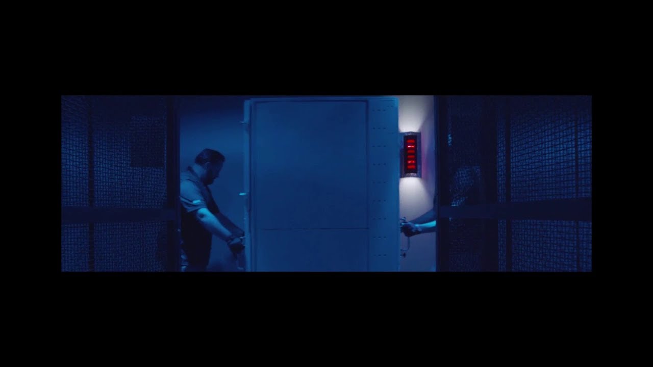 Two people opening a secure door in a blue-lit room, with mesh fencing and a red-lit security panel visible. This scene conveys a sense of security and restricted access.
