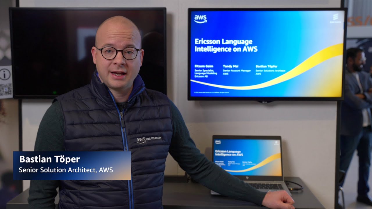 Bastian Töper, Senior Solution Architect at AWS, presents Ericsson Language Intelligence on AWS in front of a screen displaying the presentation title and participant names.