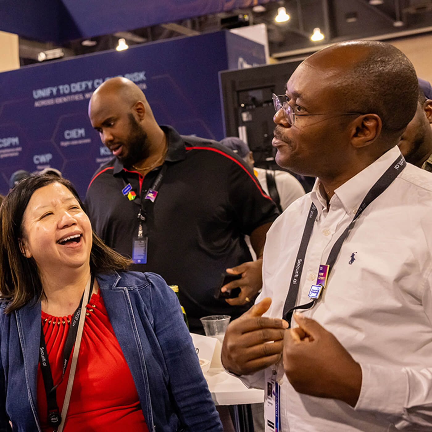 Three people engaging and networking at an AWS re:Invent event, enjoying a lively conversation in an event setting.