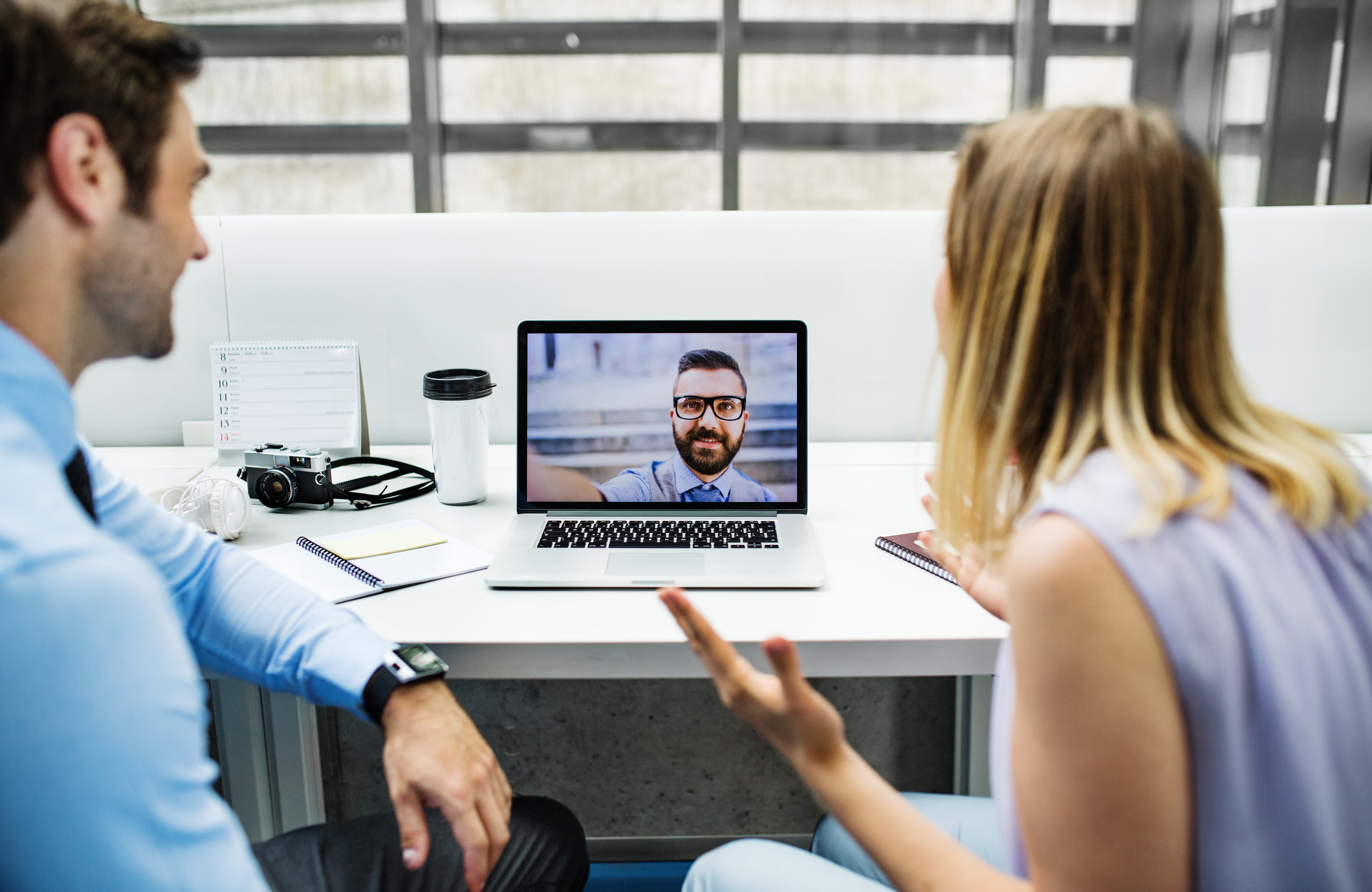 A man and woman discussing issues through conference call.