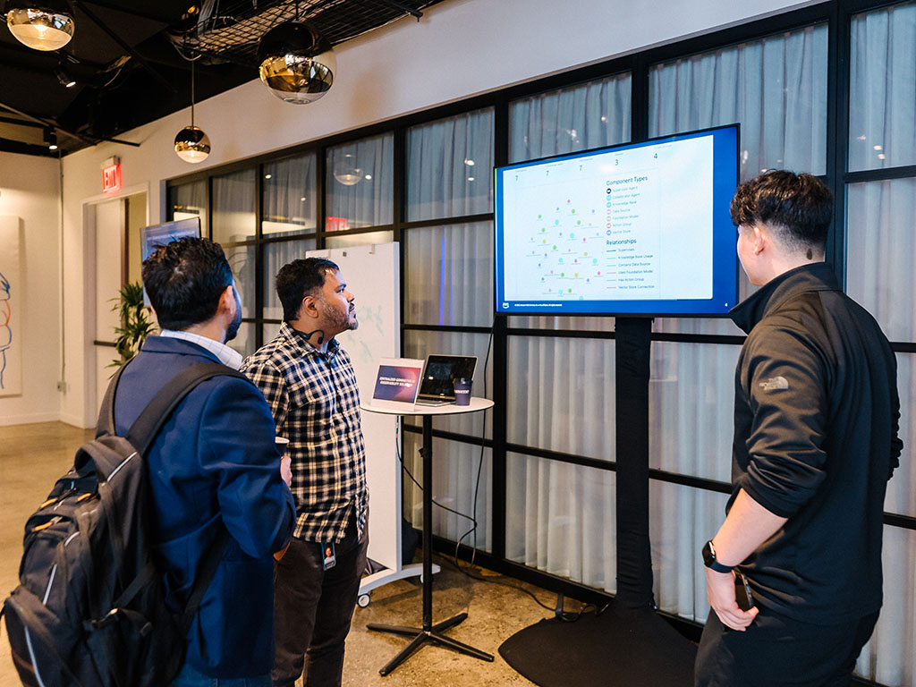 Three men looking at a monitor
