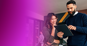 Two people collaborate while looking at a tablet, representing serverless computing and the reduction of operational complexity and cost.