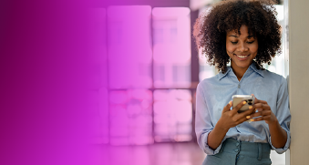 A woman smiling and using her phone, representing DevOps transformation in a modern, professional setting with AWS and LTIMindtree branding.