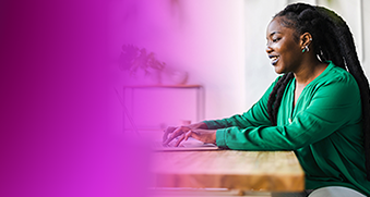 A woman in a green shirt works on a laptop at a desk, highlighting AWS DevOps EKS container security best practices.