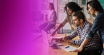 Three people collaborate while looking at a laptop in an office setting, illustrating teamwork and hybrid cloud Kubernetes best practices with AWS and Weaveworks.