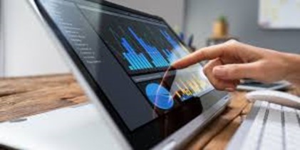 A person pointing at a colorful data chart displayed on a laptop screen.