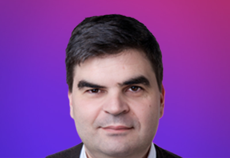 Professional headshot of a speaker at the Partner Summit Hamburg in front of a purple and pink gradient background.
