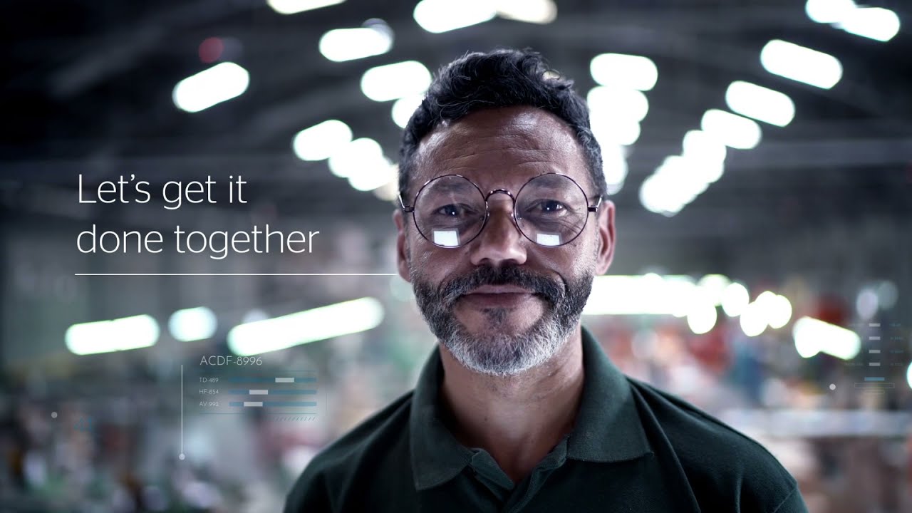A YouTube thumbnail featuring an industrial worker with glasses and a beard in a factory setting, accompanied by the motivational text 'Let's get it done together.'
