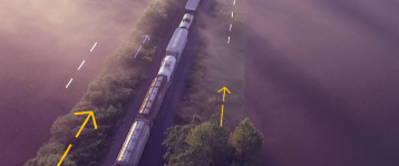 Aerial view of a train moving through a landscape with concept arrows indicating migration or movement, illustrating a migration or transition theme.