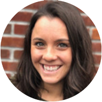 Headshot of a woman smiling in front of a brick wall