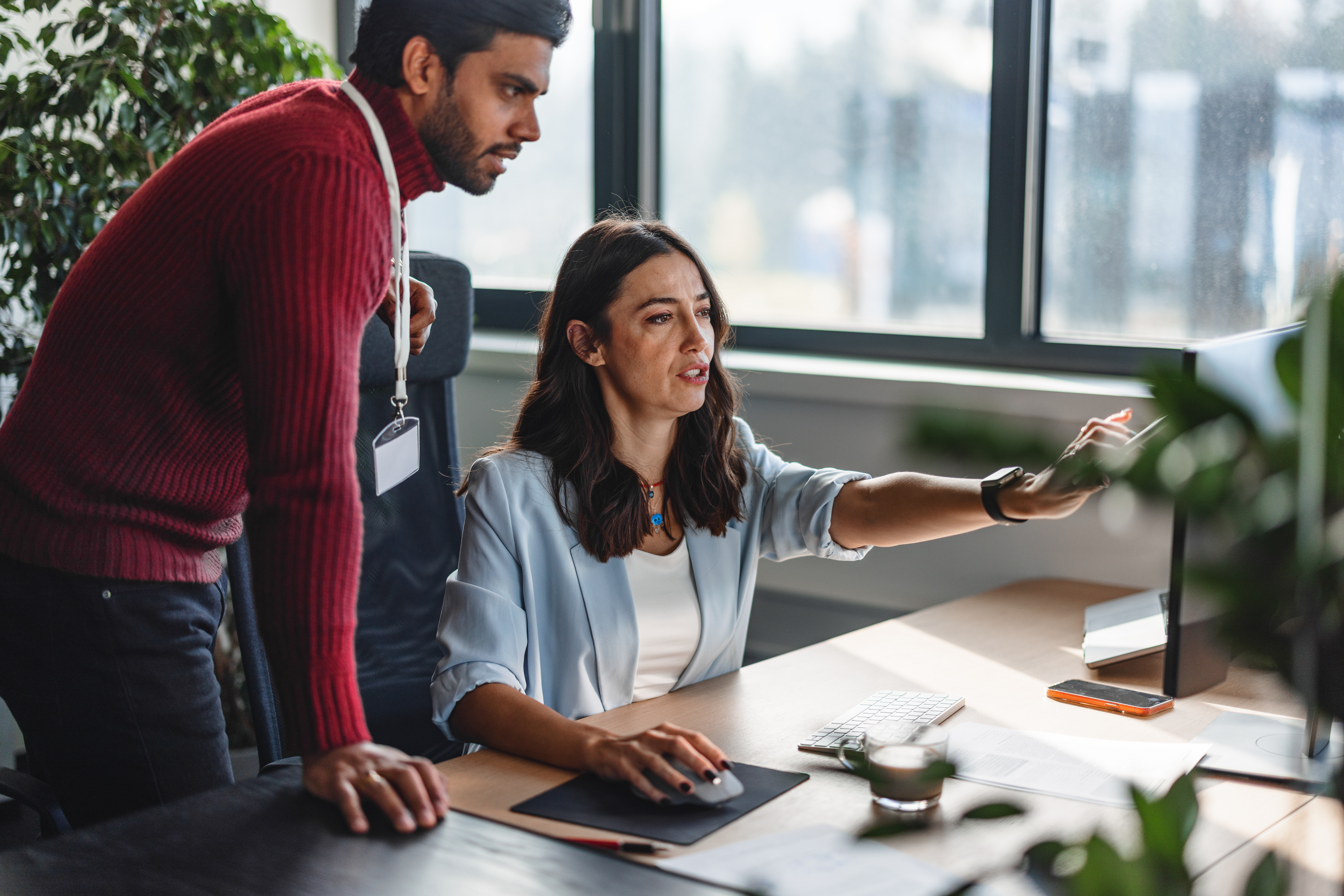 Diverse business colleagues in an office. Coworking together in an office working on a project using a desktop PC.