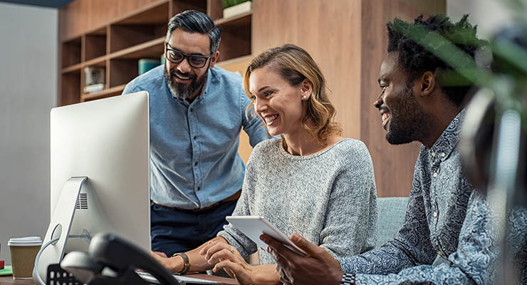 Casual businessmen and cheerful business woman in office working on a project together. Happy business man and colleagues working in a creative company. Mature businesswoman with her team working together on presentation for business meeting in office.