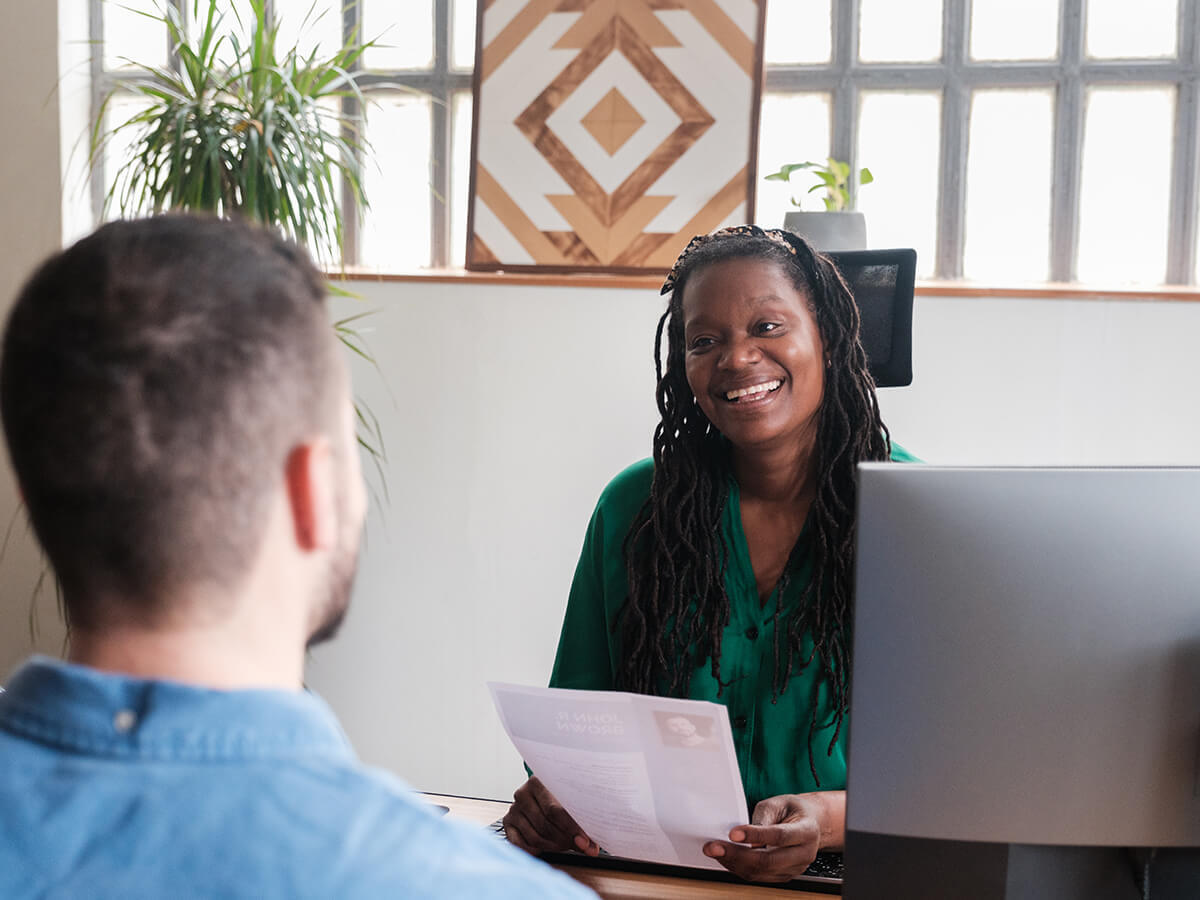 An interviewer reviews a document with a candidate across a desk