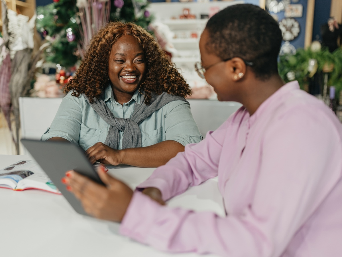 Two small business owners review information on a tablet together in their shop