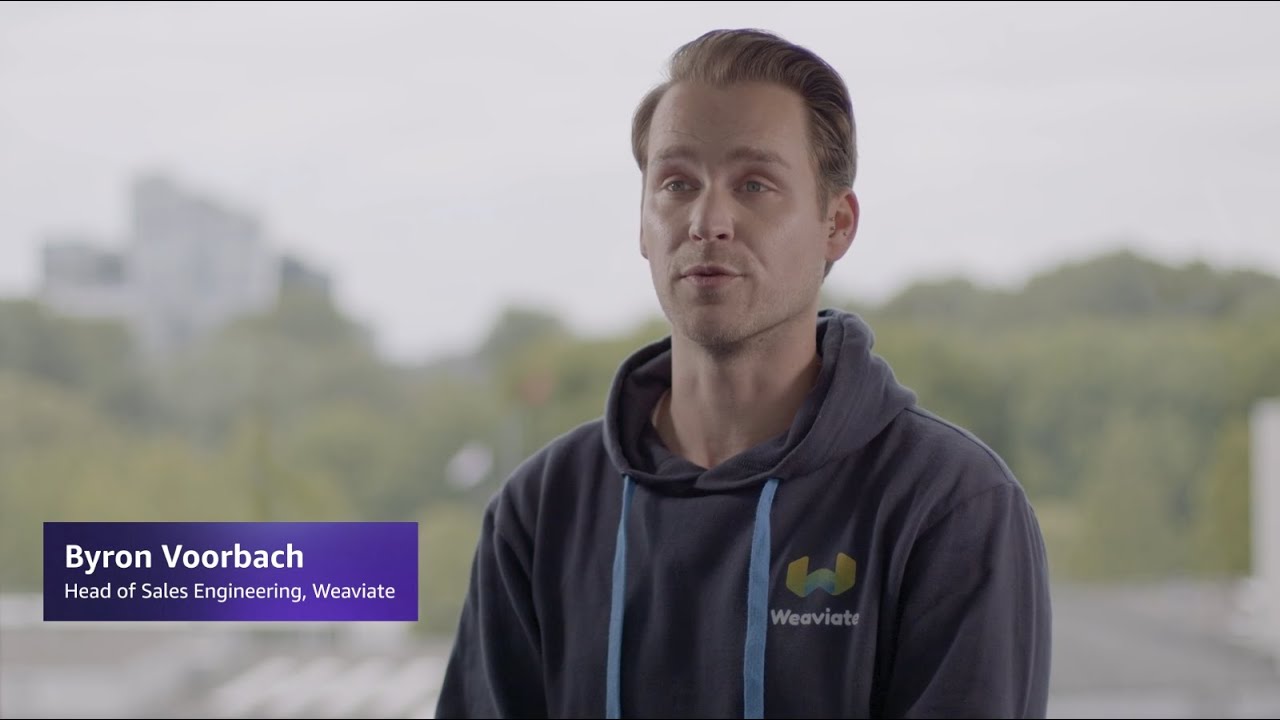 A YouTube video thumbnail featuring Byron Voorbach, Head of Sales Engineering at Weaviate, sitting indoors with a blurred, green outdoor background. Byron is wearing a dark hoodie with the Weaviate logo.