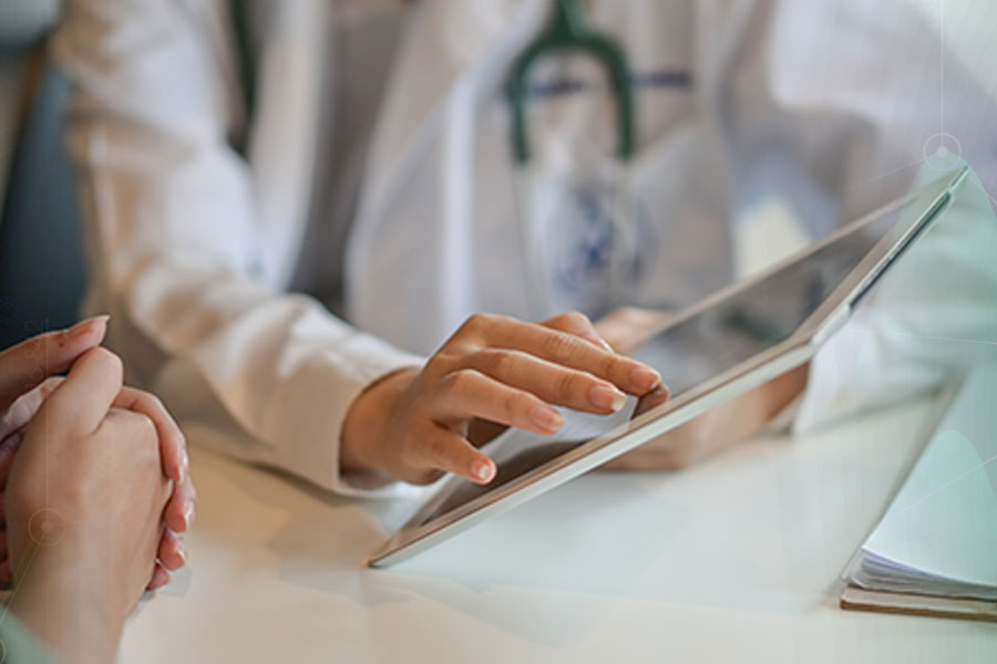 A close-up of a doctor wearing a white coat and stethoscope, using a tablet device at a desk, with a patient's hands visible, representing trust in health AI and digital healthcare solutions.