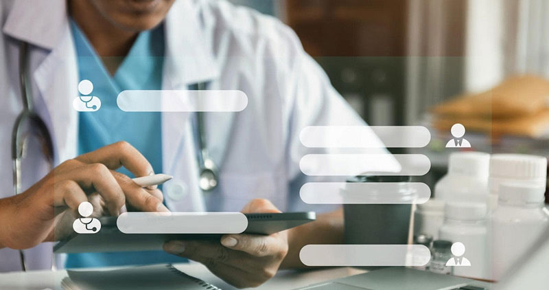 A doctor using a digital tablet with icons and charts representing digital healthcare data management. Medical supplies can be seen on the desk, illustrating technology in a modern healthcare setting.