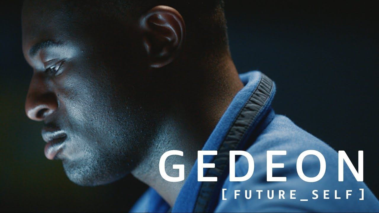 Close-up of a person wearing a blue jacket with the text "GEDEON [FUTURE_SELF]" overlaid.