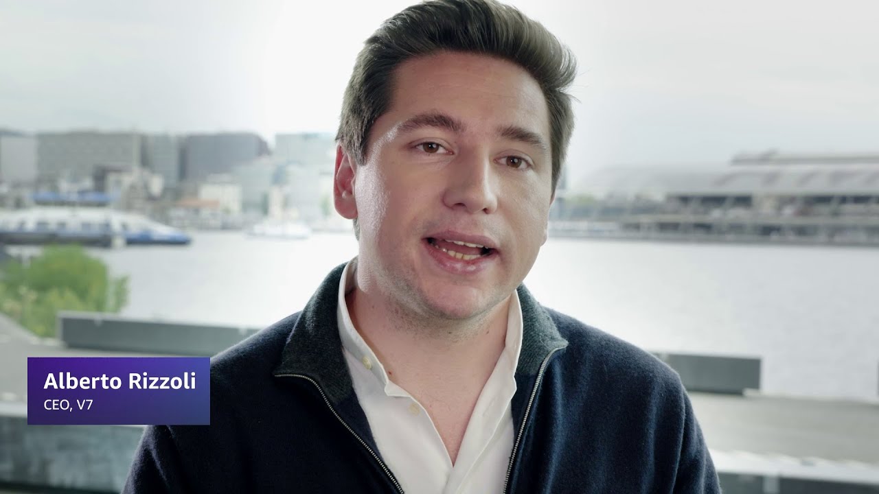 A person wearing a white shirt and dark jacket with a waterfront cityscape in the background; text overlay reads "Alberto Rizzoli, CEO, V7."