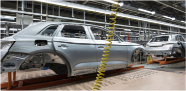 Silver car frames on an assembly line in a factory setting.