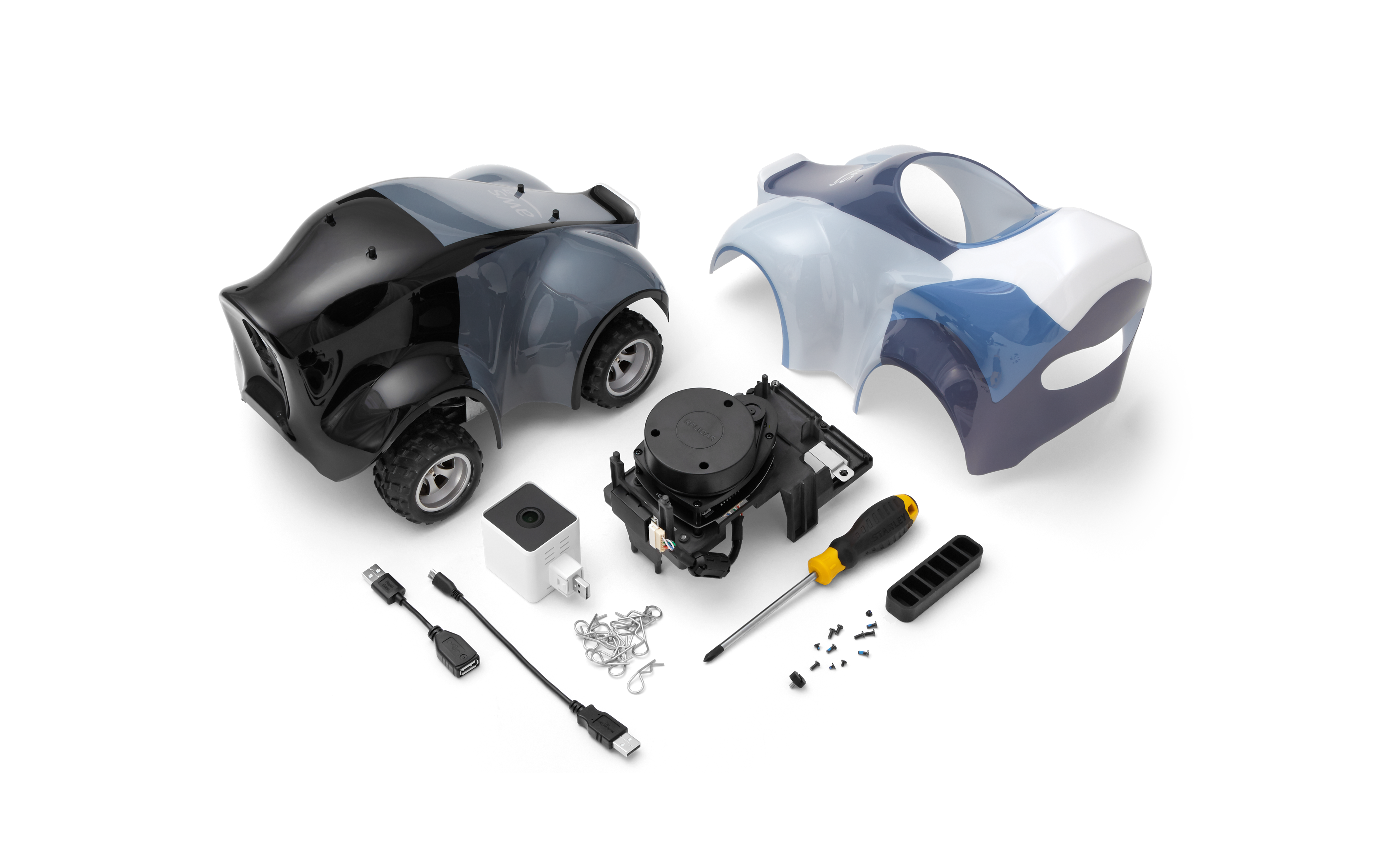 A top-down view of the EVO Sensor Kit, featuring the disassembled parts of a miniature vehicle, casing components, a sensor, screwdrivers, wires, screws, and USB cables. The kit is used for machine learning, robotics, and AI development purposes.