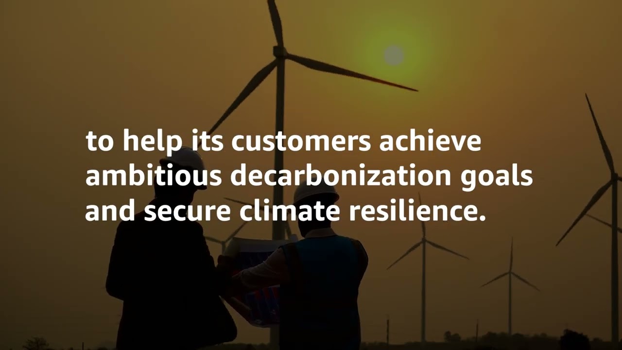 YouTube thumbnail image showing two people in front of wind turbines at sunset, with overlaid text about helping customers achieve ambitious decarbonization goals and secure climate resilience.