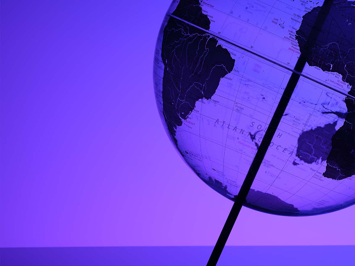 A close-up, stylized image of a globe showing the South Atlantic Ocean and parts of South America and Africa, with a purple color overlay.