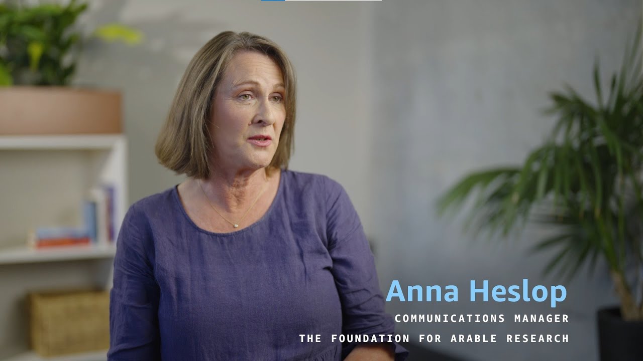 Anna Heslop, Communications Manager for The Foundation for Arable Research, with a blurred face, seated in a room with a bookshelf and a plant in the background.