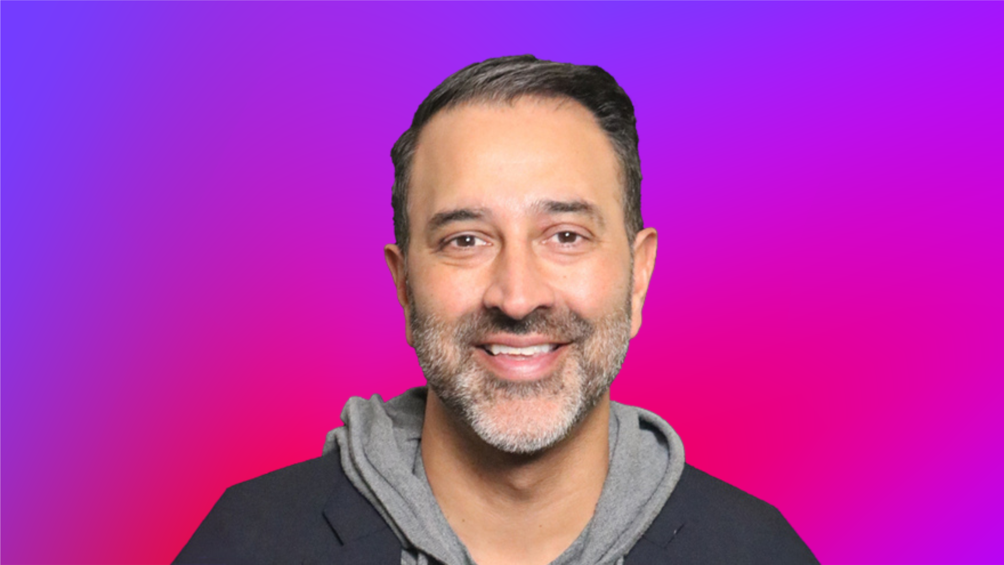 A person wearing a gray hoodie and dark jacket against a vibrant gradient background of purple and pink.