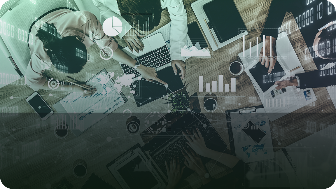 Overhead view of a business team analyzing data with digital graphs and charts overlayed, working collaboratively with laptops and documents on a wooden desk.