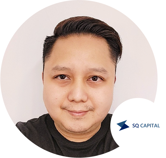 Profile photo of a man with short dark hair, wearing a black shirt, with the SQ Capital logo in the corner.