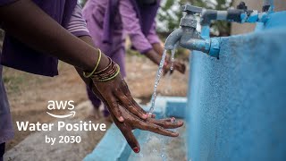 Hands being washed under a running tap, with text "AWS Water Positive by 2030" displayed.