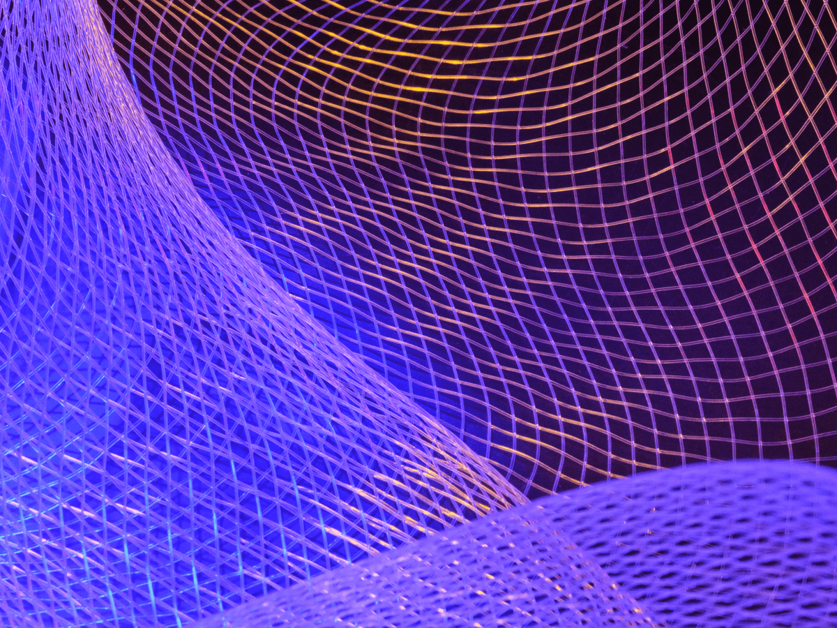 An abstract image of a mesh or grid pattern highlighted with purple and blue lighting, creating a dynamic, futuristic texture. Suitable for representing technology, computing, or modern digital concepts.