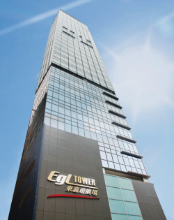 Tall modern skyscraper labeled "EGL Tower" against a bright blue sky.