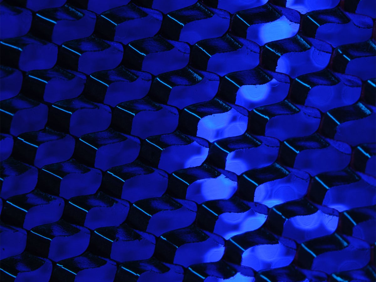 Close-up of a repeating, abstract pattern with blue lighting, creating a futuristic and geometric visual effect.