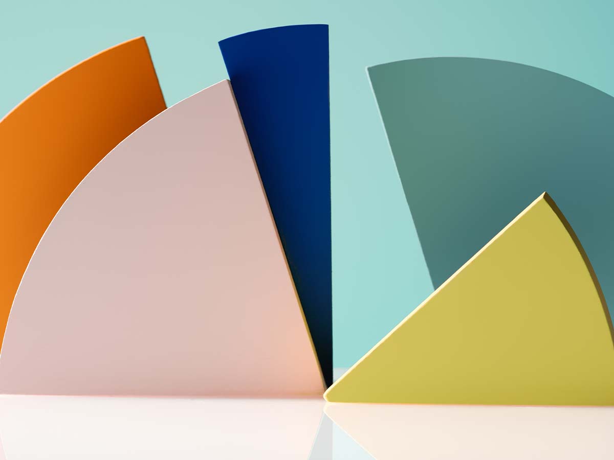 Abstract image featuring geometric shapes in pastel orange, pink, blue, green, and yellow, arranged against a light blue background.