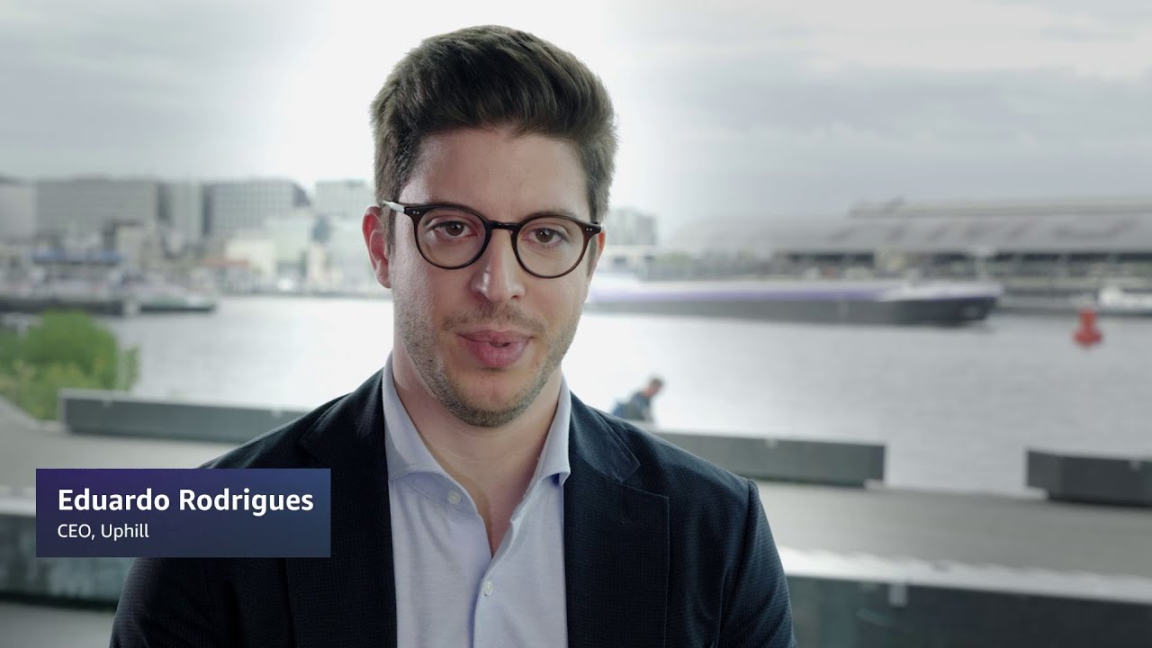 A man in a suit with a waterfront cityscape in the background, labeled as Eduardo Rodrigues, CEO of Uphill.