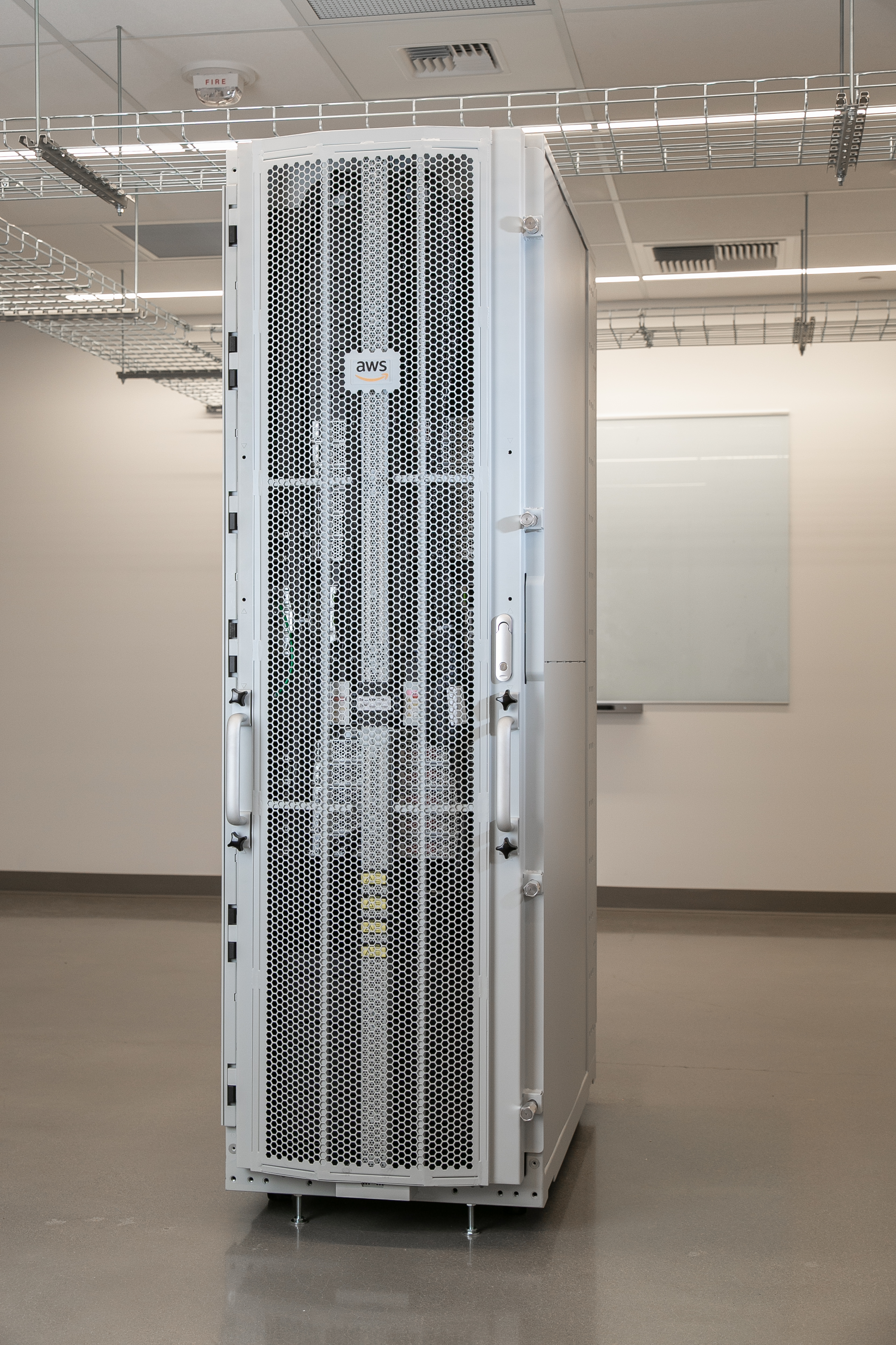 A white AWS server rack with a perforated front panel in a clean, modern room.