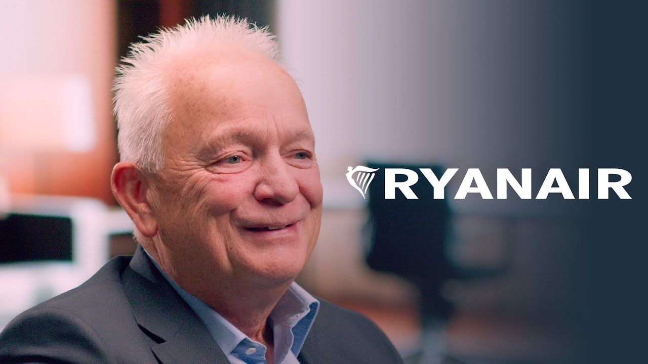 A smiling executive in a suit is pictured in an interview setting with the Ryanair logo prominently displayed on the right side, suggesting a professional discussion or testimonial related to Ryanair.