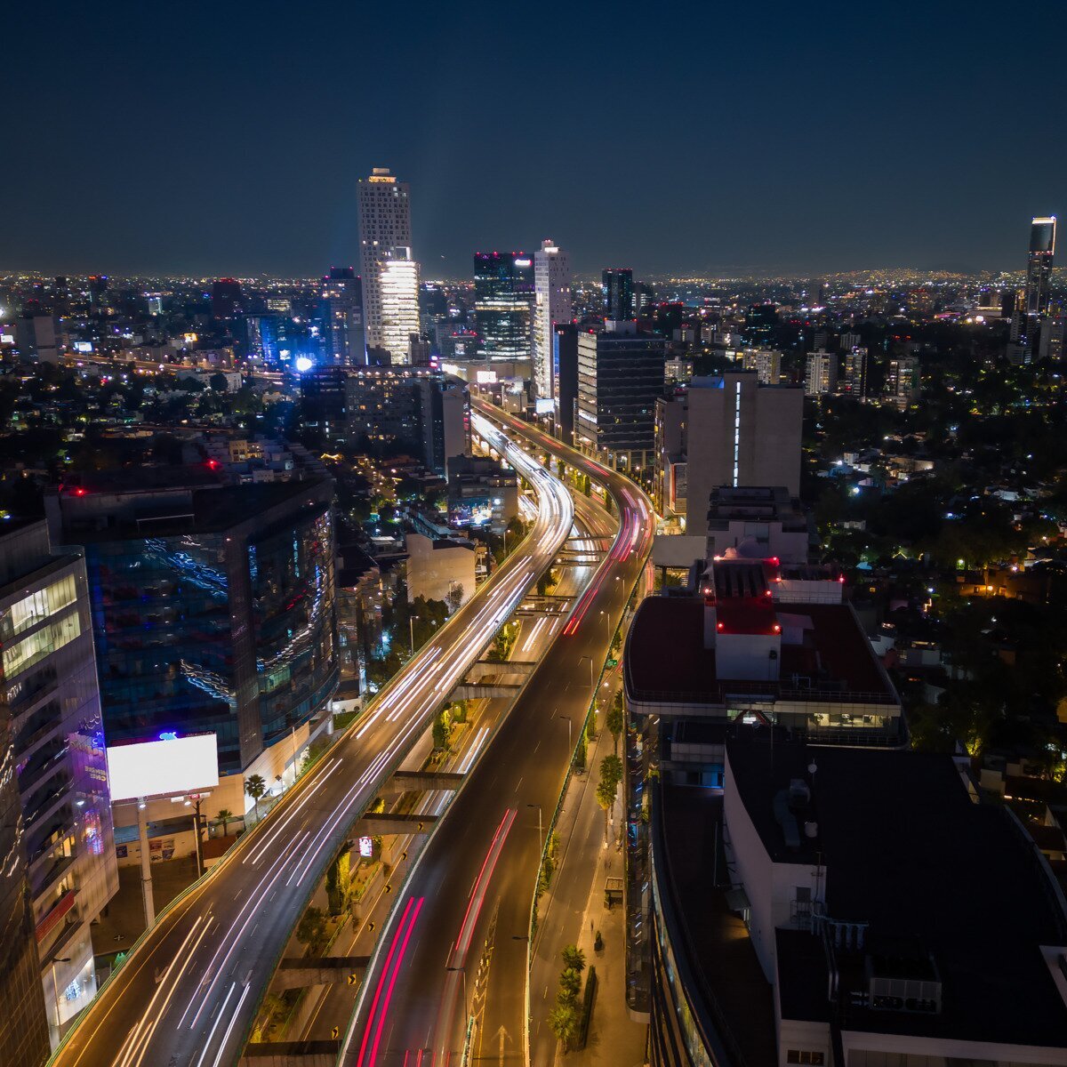 A night-time aerial overview of city traffic with light trails from vehicles, highlighting dynamic movement and urban infrastructure. Represents data flow and time-series analysis for AWS Timestream database features.