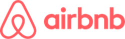 The red text icon of the Airbnb logo, featuring the distinctive Airbnb symbol and the brand name in lowercase red typography.